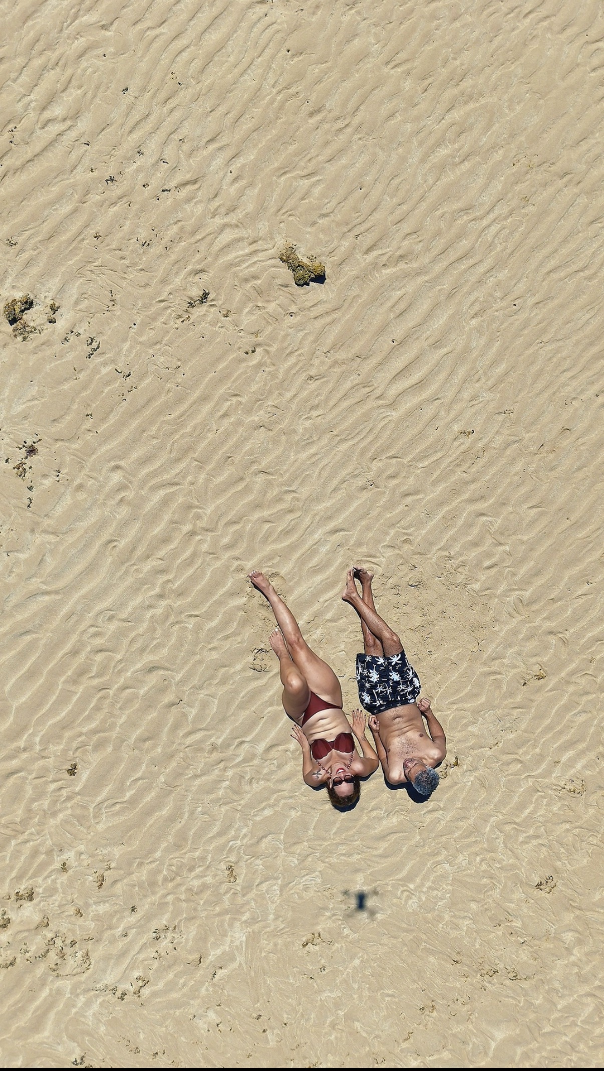 Casal descansando no banco de areia visto do alto