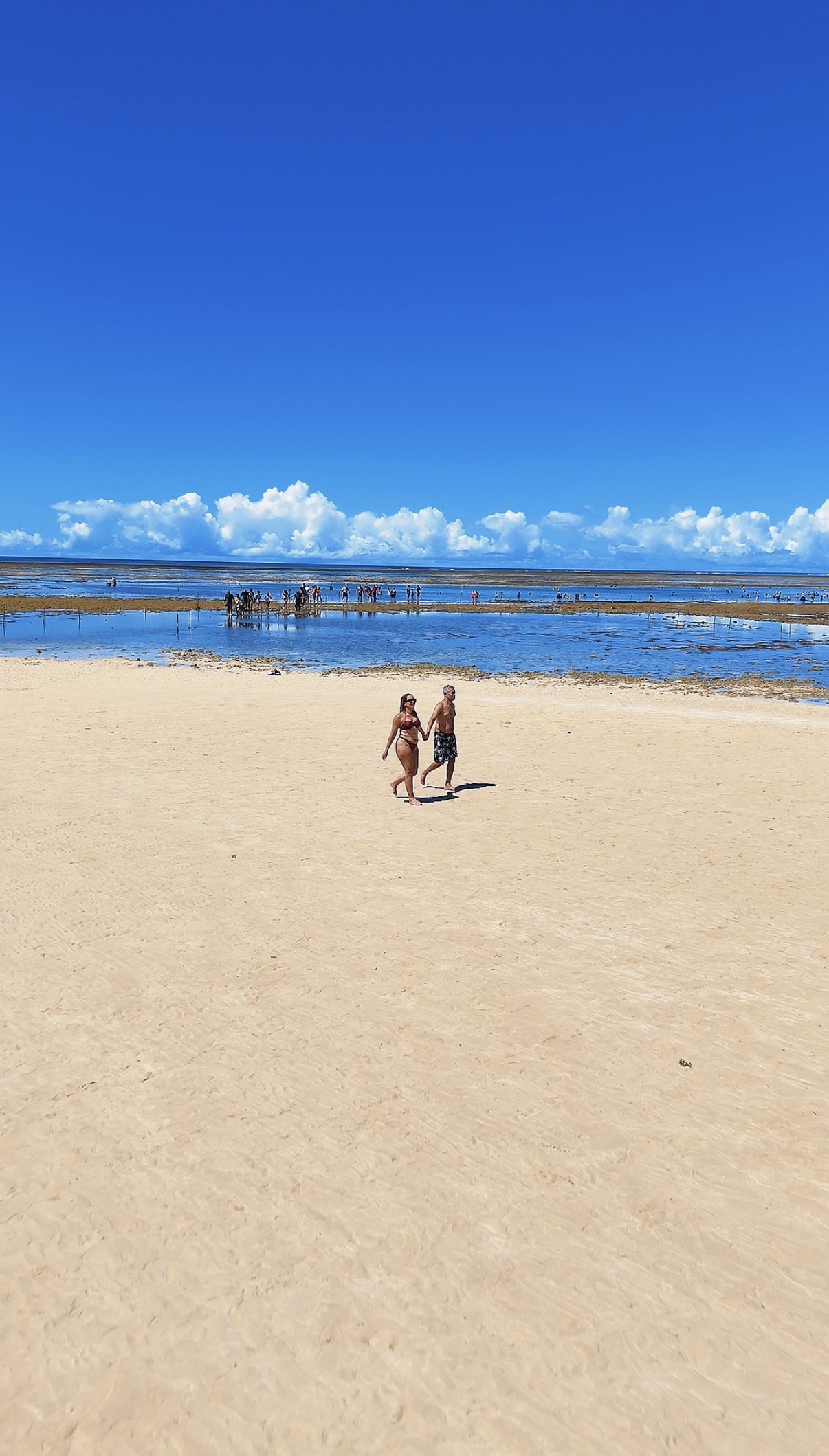 Casal caminhando pelo banco de areia em Recife de Fora