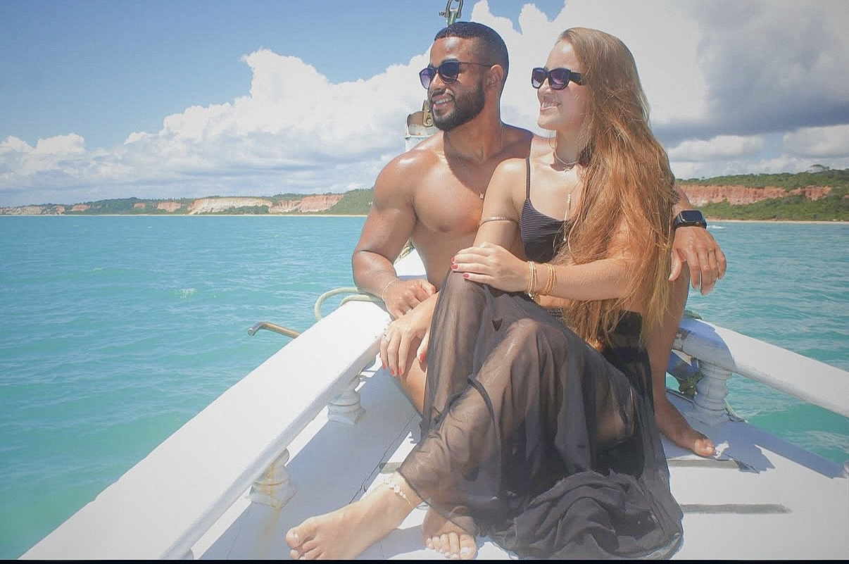 Casal no convés com o litoral de Trancoso ao fundo